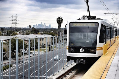 An Expo Line test train rests at the La Cienega station, with the downtown L.A. skyline in the distance. Photo by Steve Hymon/Metro via Wikipedia.